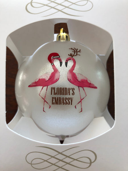 The back of the ornament features two flamingos wearing Santa Hats and the words "Florida's Embassy"